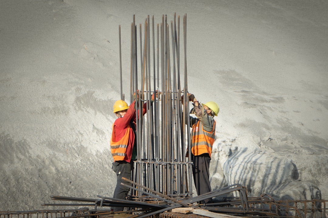 Dois Homens Que Trabalham Em Um Canteiro De Obras cWPULrqLCL8