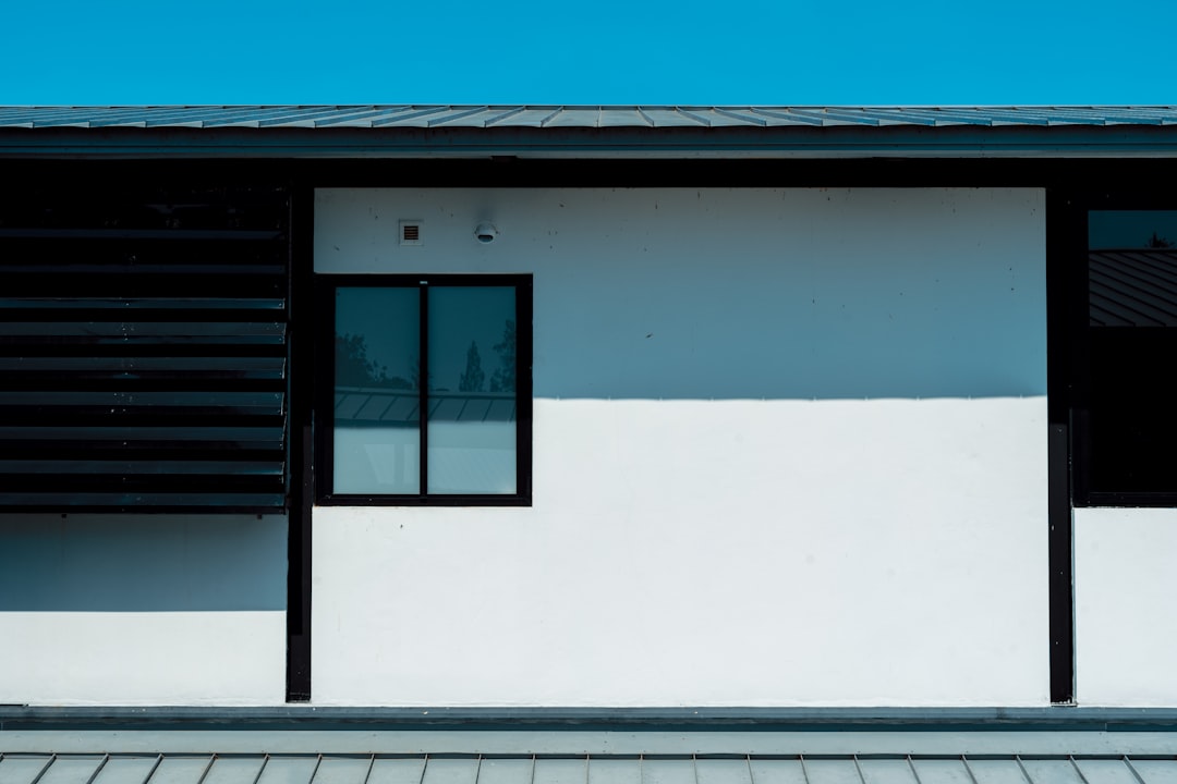 Um Edificio Preto E Branco Com Um Relogio Ao Lado Dele cOR2WmsN0MY