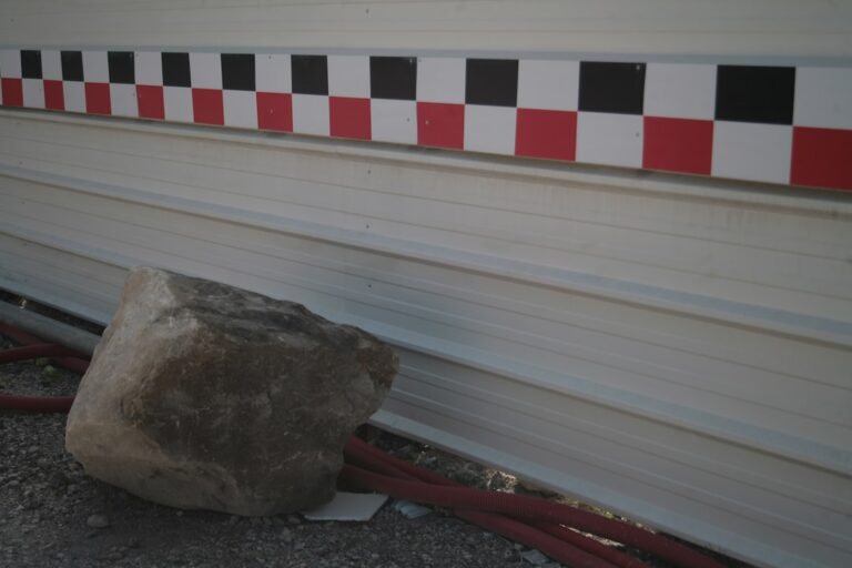 Uma Rocha Sentada Ao Lado De Um Edificio 9CTzNcUAFQM