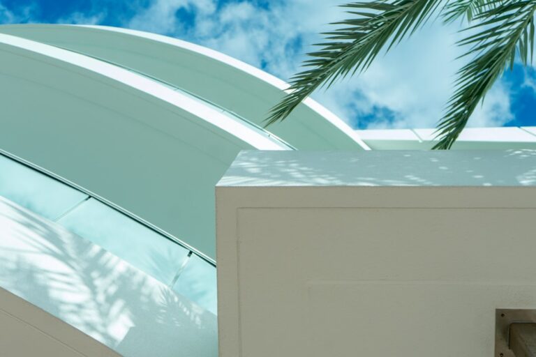 Um Edificio Branco Com Uma Palmeira a Sua Frente Ie6mtOokiZw