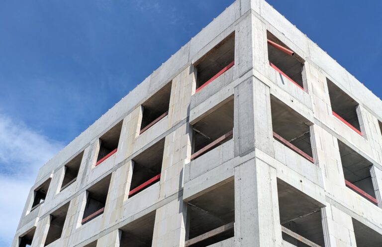 Um Edificio De Concreto Alto Sob Um Ceu Azul ZDB7 2Yksh8