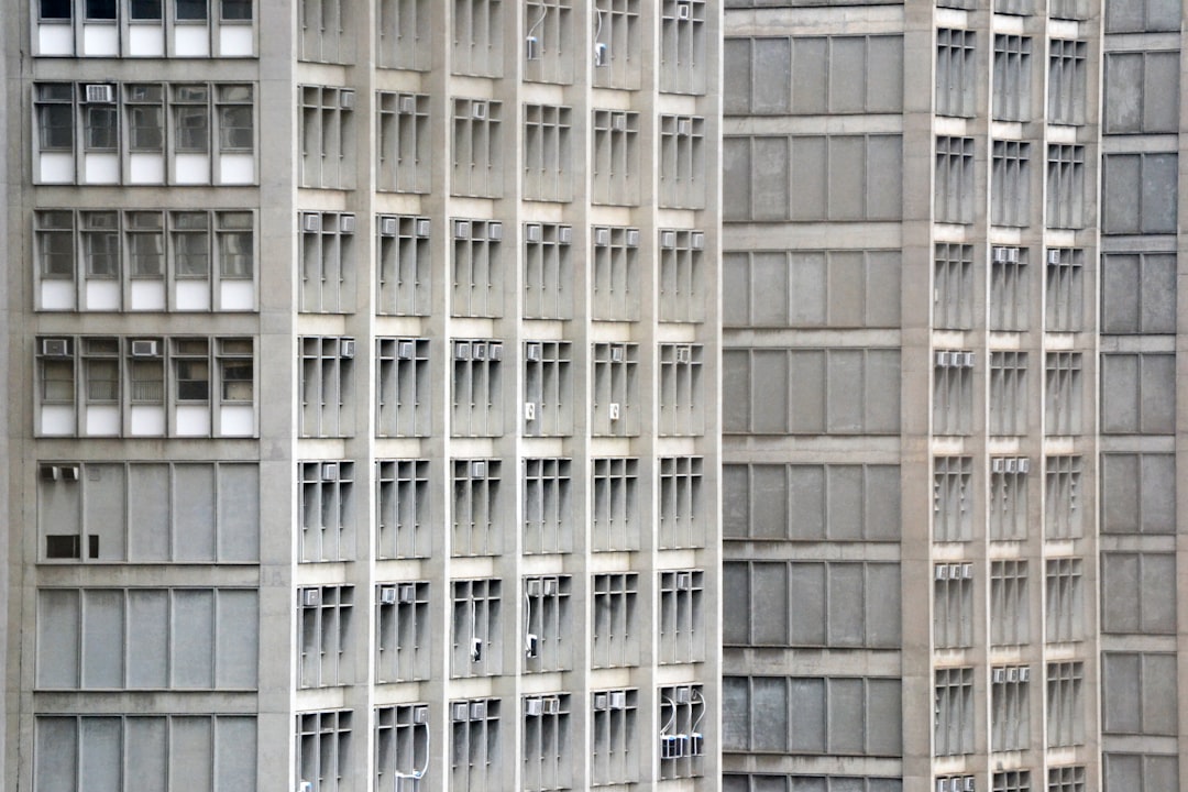 Um Edificio Alto Com Muitas Janelas Ao Lado De Um Parquimetro A0NW61c4ZpY