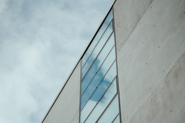 Um Edificio Alto Com Um Reflexo Do Ceu Nele K_NPXG4S00o