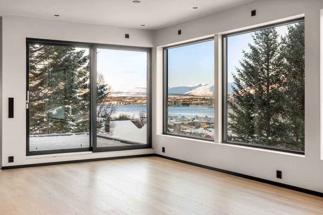 Uma Sala Vazia Com Grandes Janelas Com Vista Para Um Lago IiGVJA3JlNs