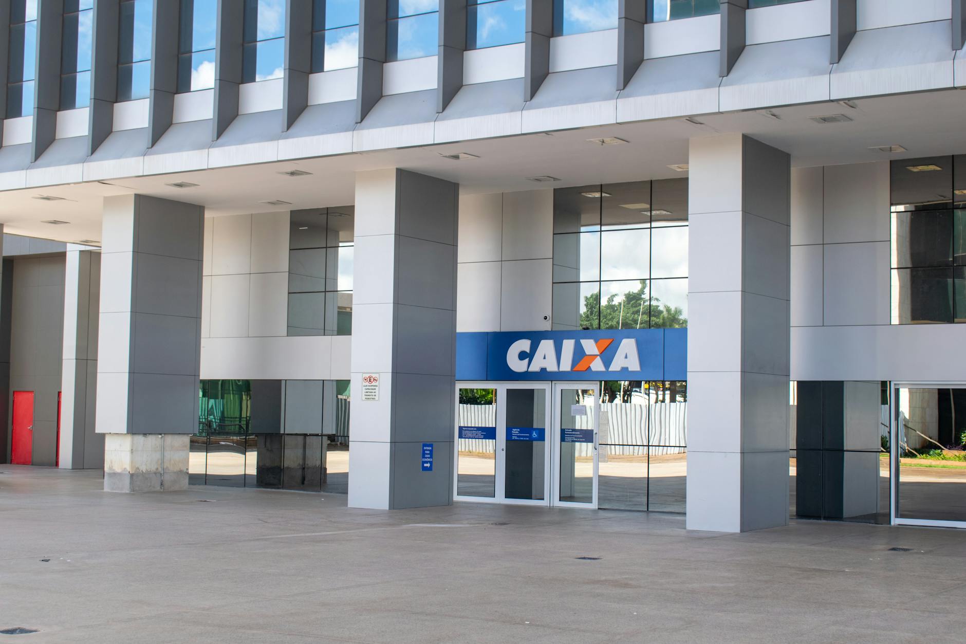 Entrance of a modern Caixa bank building in Brasília showing architectural details.