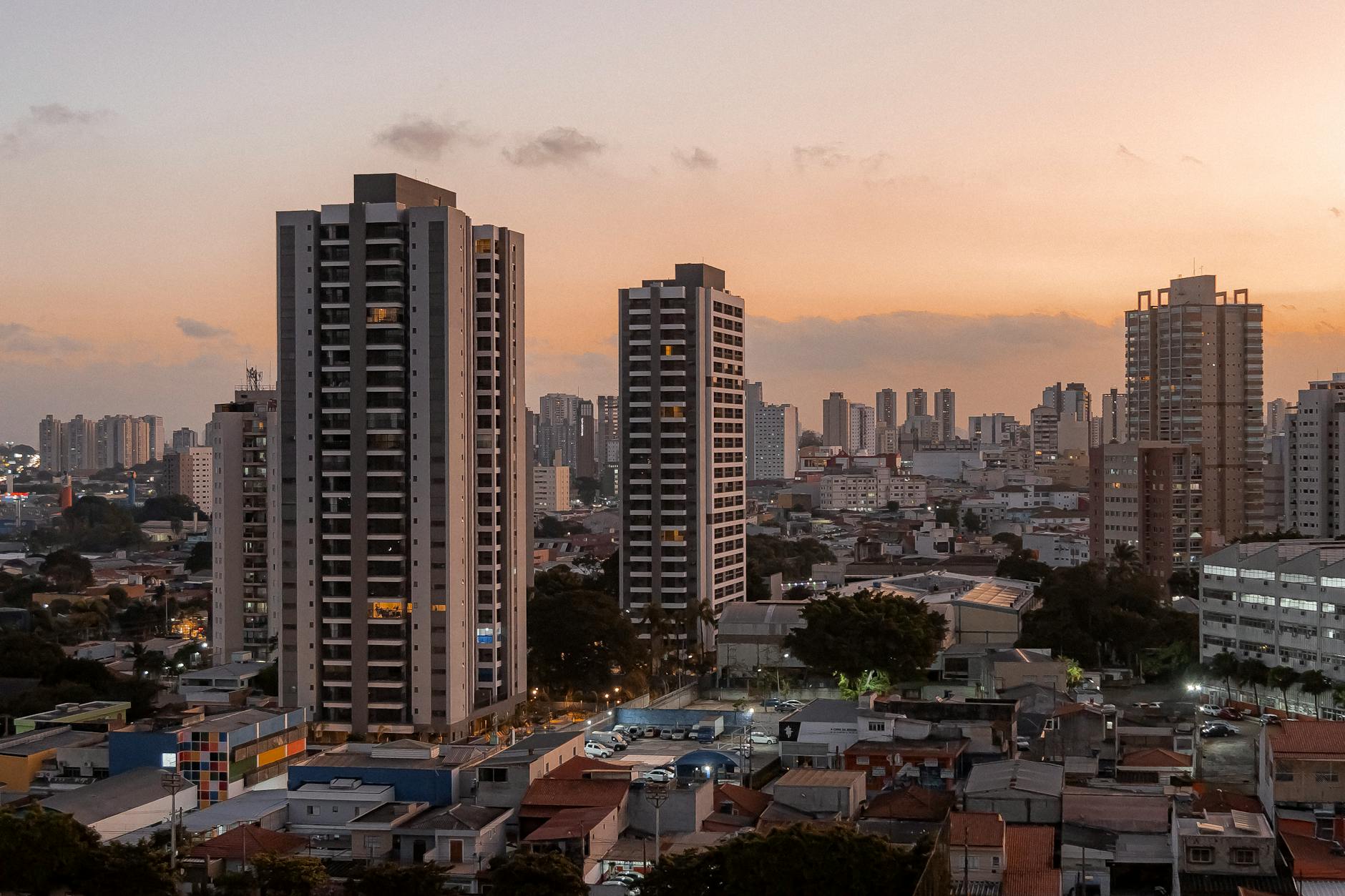 A stunning cityscape at sunset featuring towering high-rise buildings in an urban environment.