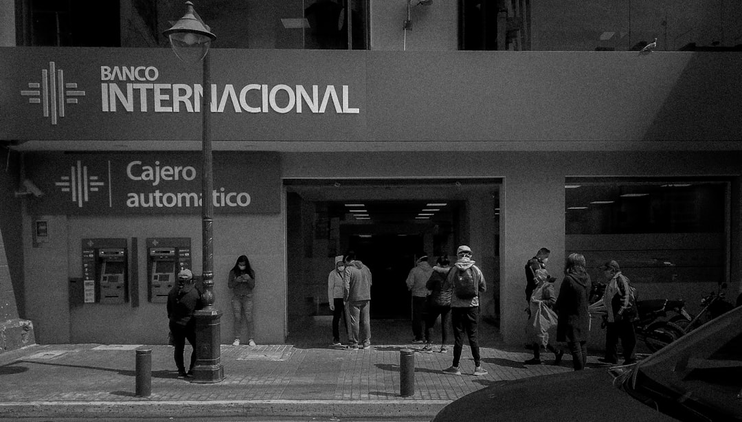 Um Grupo De Pessoas Do Lado De Fora De Um Predio FyXP3KzLp5A