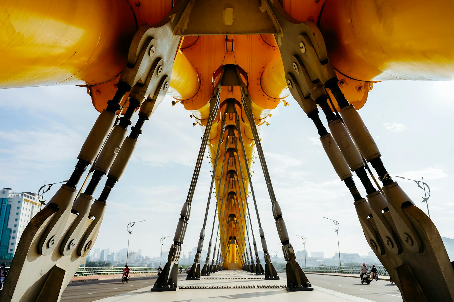 Dramatic view of the Dragon Bridge's engineering with a cityscape in the background.