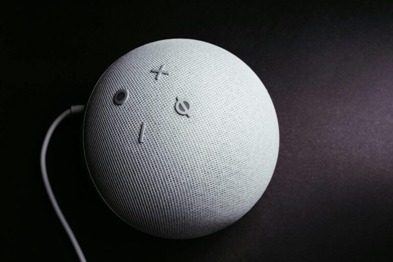 Close-up of a smart speaker on a black background, showcasing minimalistic elegance.