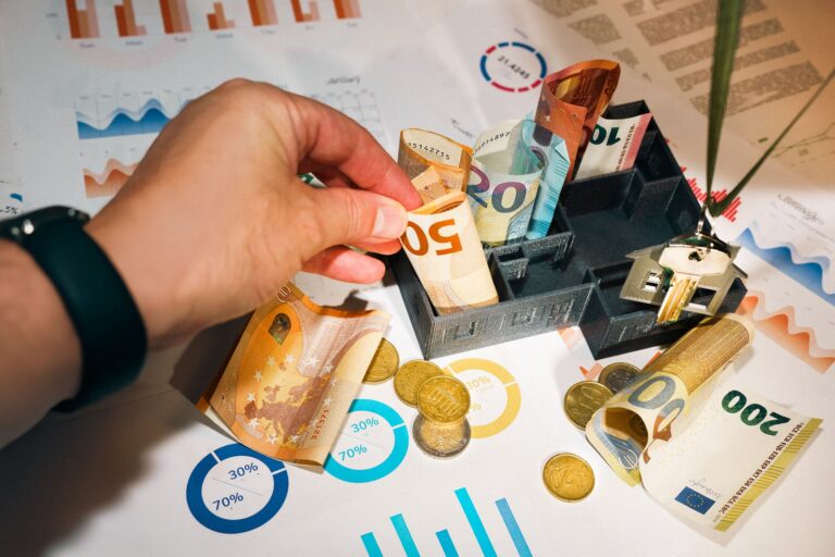 Euro bills and coins with financial charts showcasing budgeting and investment planning.