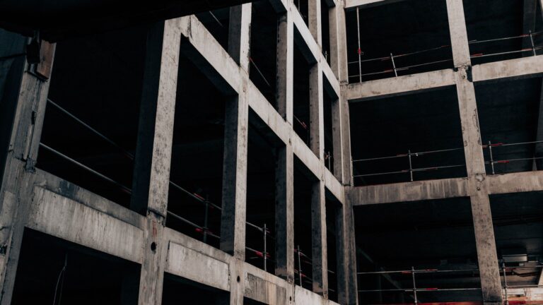 Low angle of unfinished abandoned building with concrete walls at construction site in industrial area