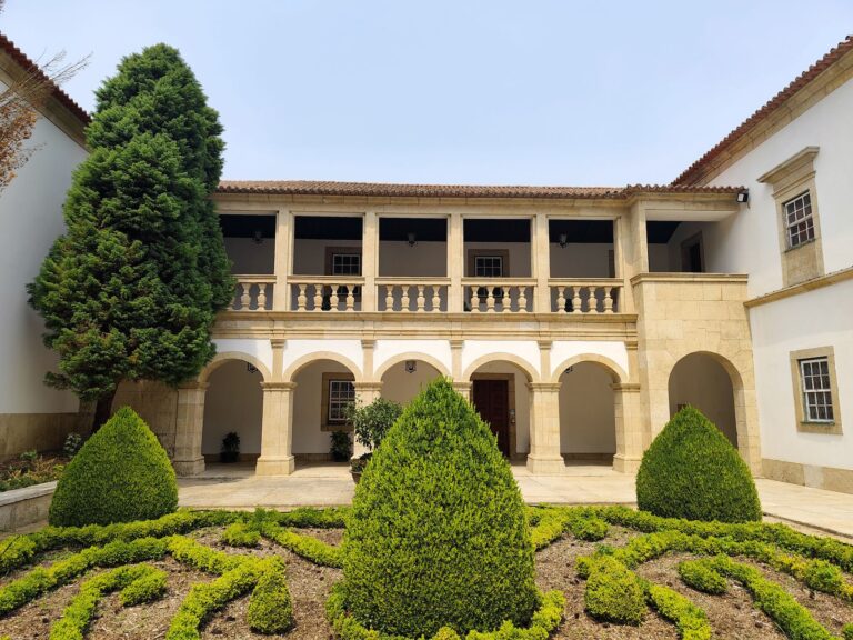 Beautiful courtyard with manicured hedges and columns in Gouveia, Portugal.