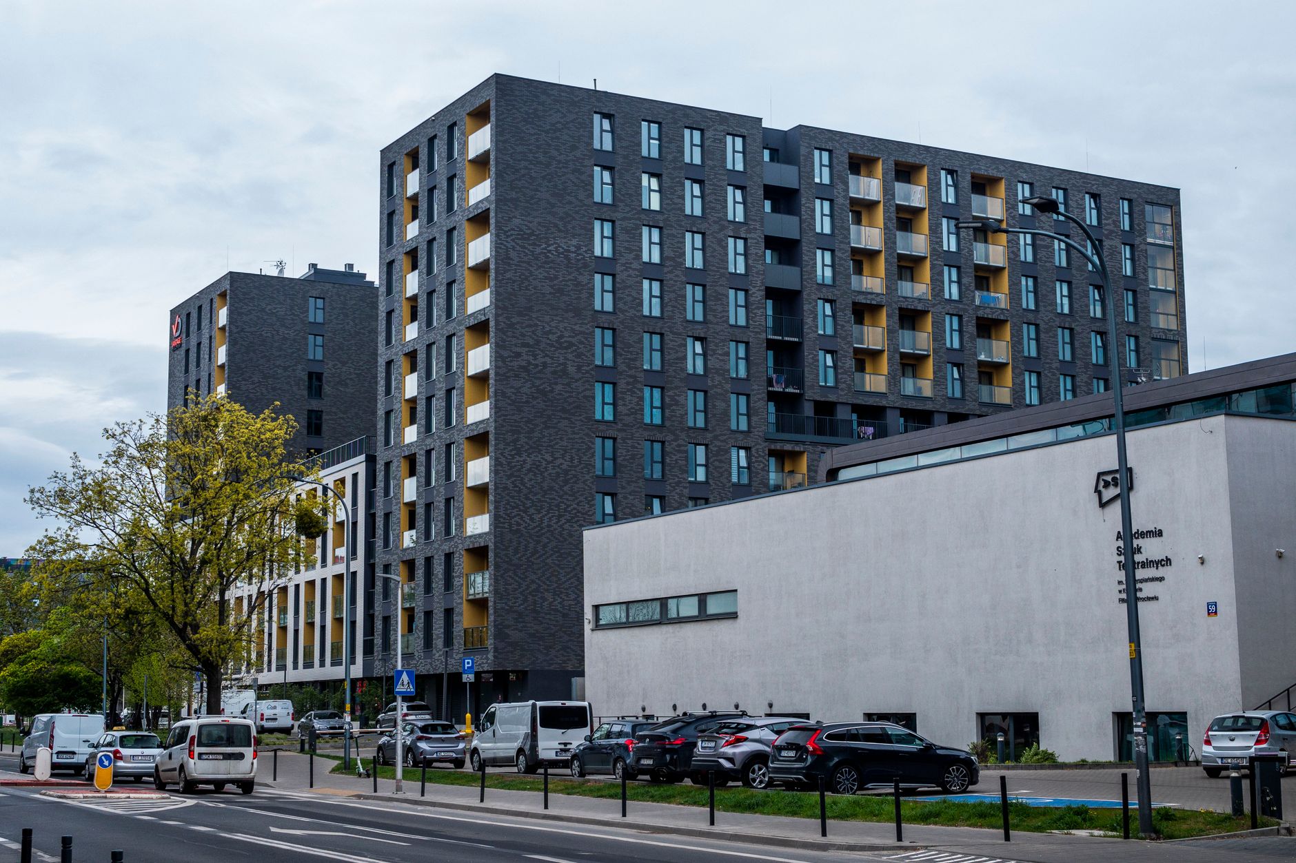 Contemporary architecture of residential buildings in an urban setting, featuring modern design and street elements.