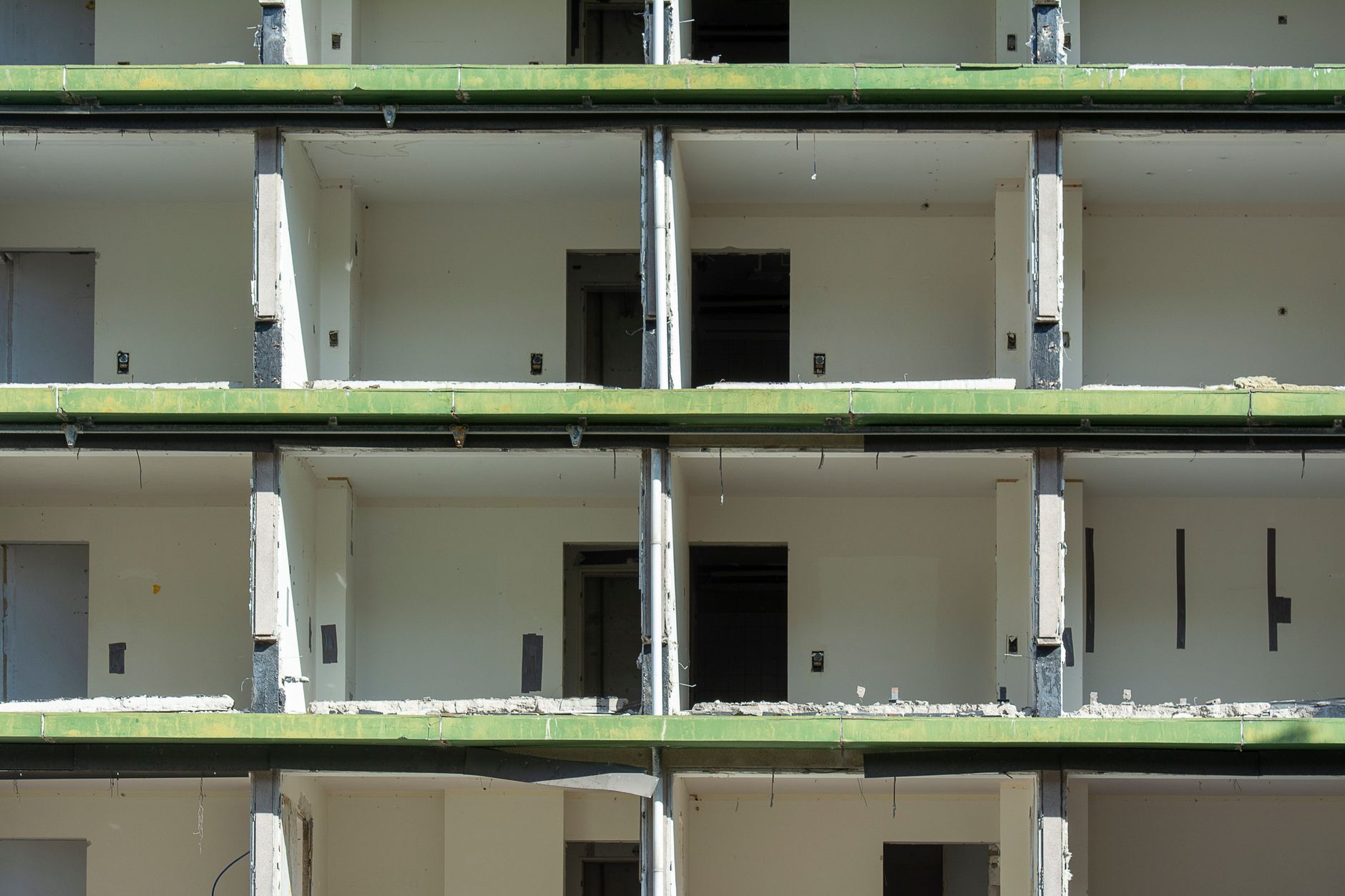 Close-up view of a partially demolished urban building showing exposed concrete and empty rooms.