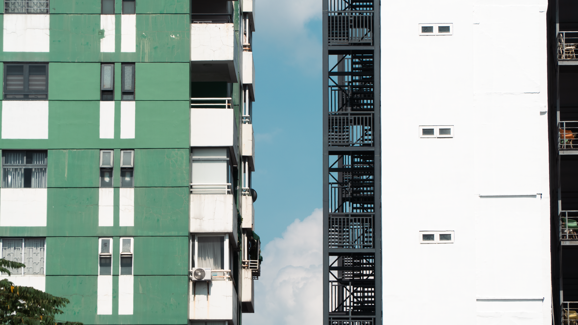 Urban architecture featuring contrasting building facades under a clear blue sky.