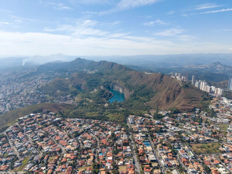 Scenic aerial view of Belo Horizonte, showcasing Serra do Curral and urban development surrounding a lake in Minas Gerais, Brazil.