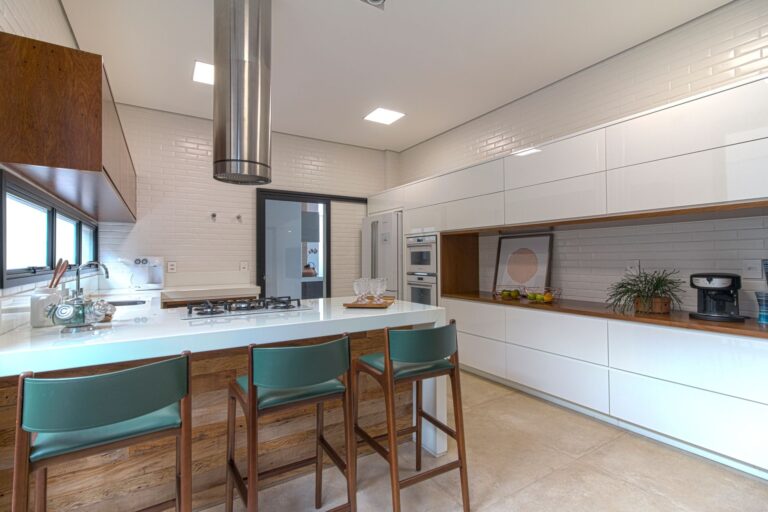 Elegant kitchen featuring white cabinetry and a central island with bar stools.
